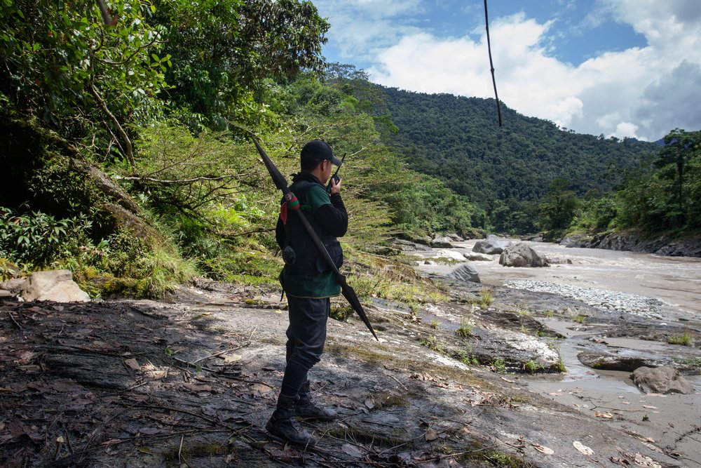 Marcelo Lucitante, a member of the Cofan indigenous guard, speaks on a radio while on patrol on the banks of the Aguarico River in northern Ecuador near their village of Sinangoe, on April 21, 2022. Thomson Reuters Foundation/Fabio Cuttica